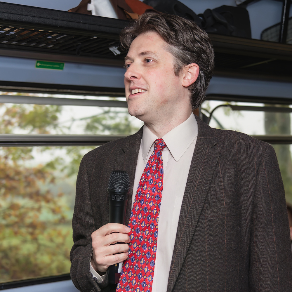 Actor dressed as James Herriot onboard train wearing microphone